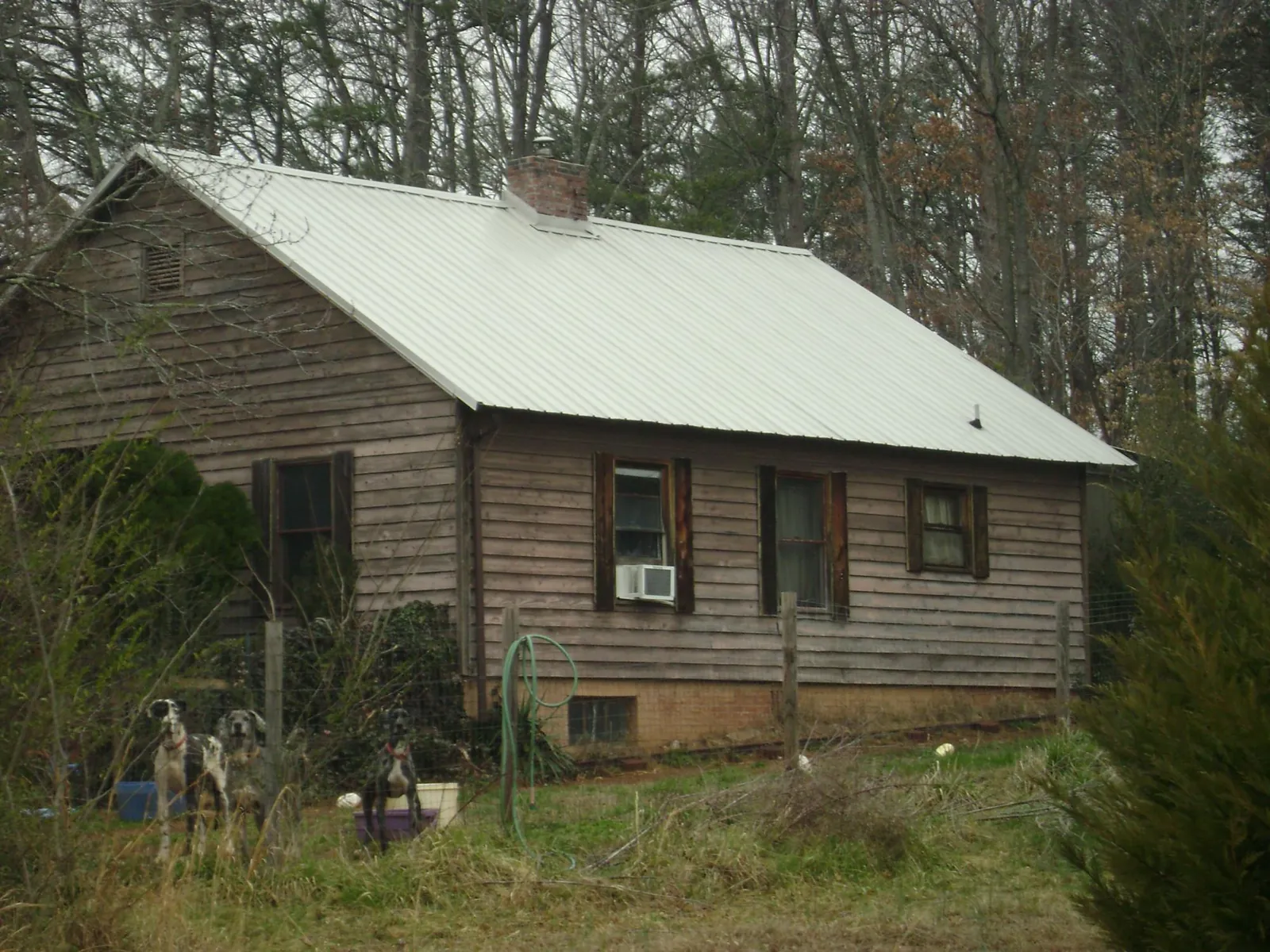 White metal roof on an old wood sided farmhouse, from a Metal Roof Installation job in Rush